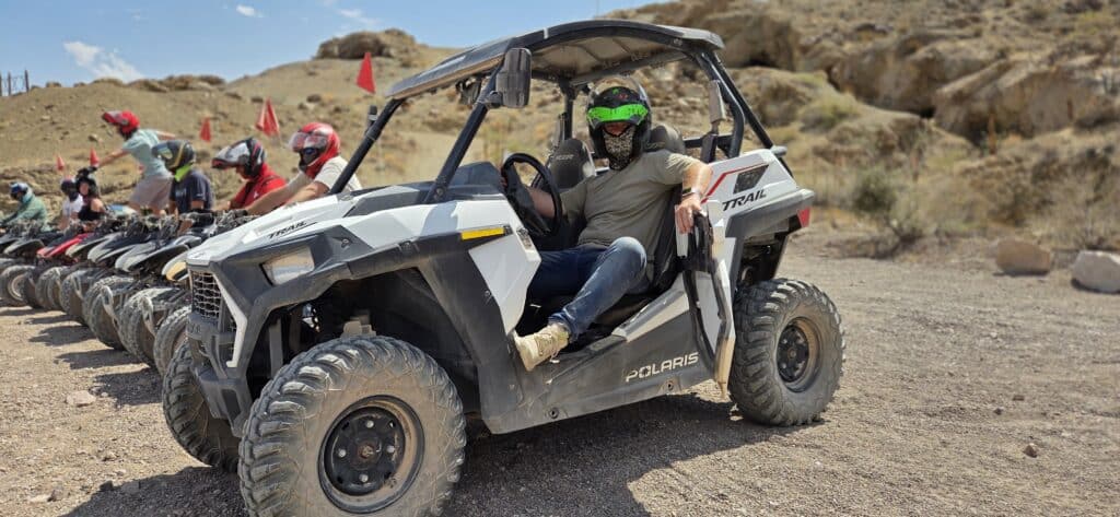 Experience a Las Vegas RZR off-road ride in Nevada, with ATVs on rocky terrain and a sunny sky—perfect for adventure tours.