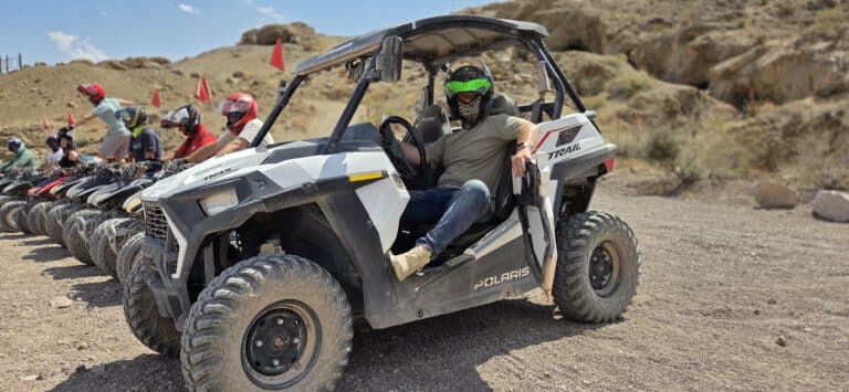 Experience a Las Vegas RZR off-road ride in Nevada, with ATVs on rocky terrain and a sunny sky—perfect for adventure tours.