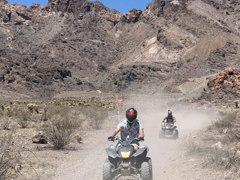 Adventure seekers enjoy an ATV tour near Las Vegas, riding dusty desert trails by Nevada’s rocky mountains and sparse shrubs.