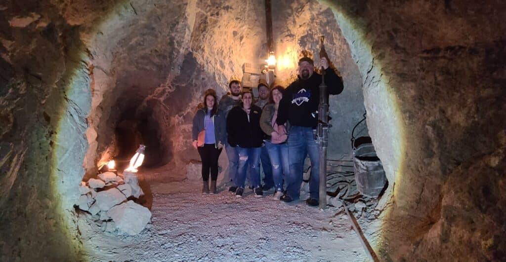 Six adventurers explore a dim cave on a Las Vegas ATV tour near the Colorado River and Nevada Ghost Towns.