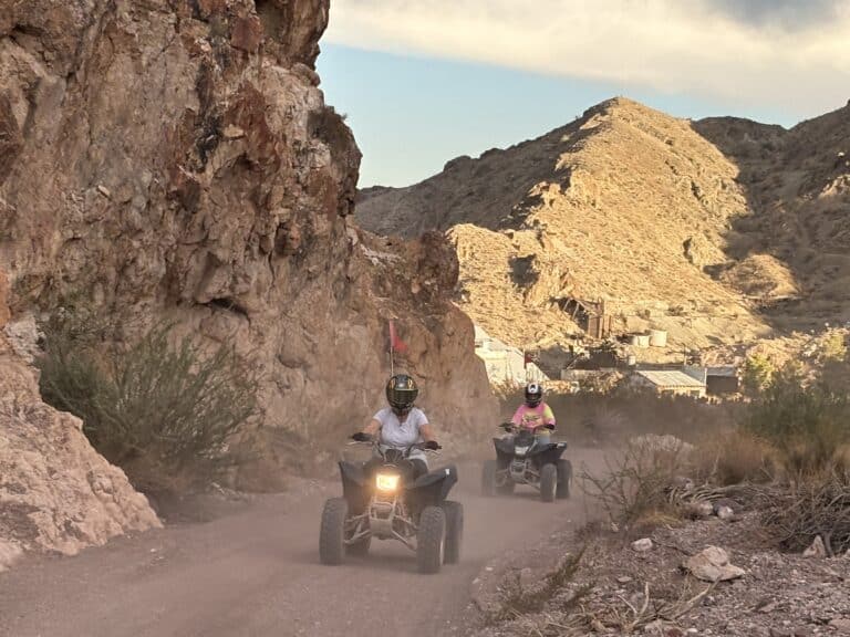 ATV riders explore a dusty desert trail near Las Vegas, Nevada, with sunlit hills and rugged canyon views on an exciting off-road tour.