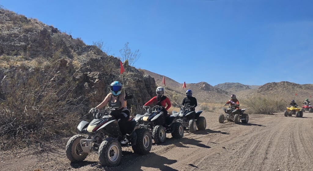 ATV tour group riding along a dirt road near the Colorado River in Nevada, exploring scenic desert trails outside Las Vegas.