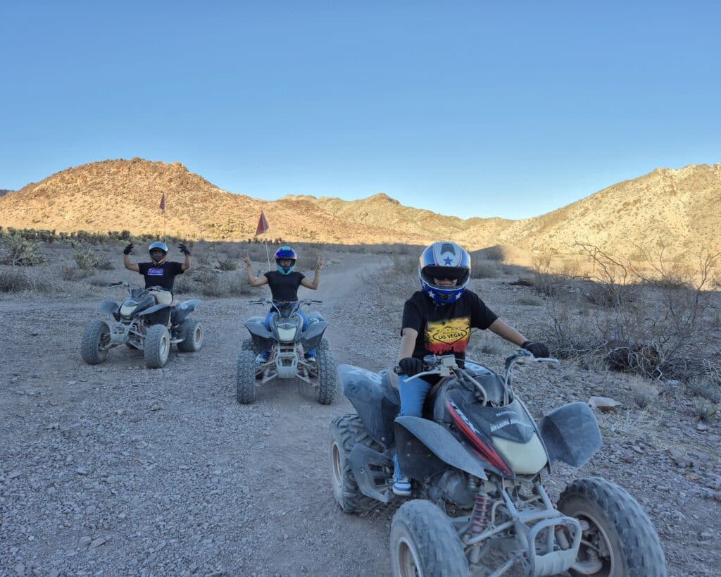 Adventurers on an ATV tour near Las Vegas ride rocky desert trails with mountain views under clear Nevada skies.