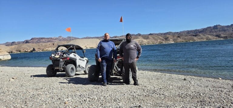 Adventurers by off-road vehicles with orange flags on Nevada’s Colorado River lakeshore near Las Vegas—perfect for ATV and RZR tours.