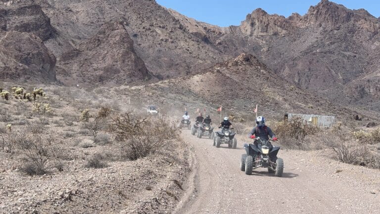 Adventurers on ATVs enjoy a thrilling off-road tour along a desert dirt road near the Colorado River in Las Vegas, Nevada.