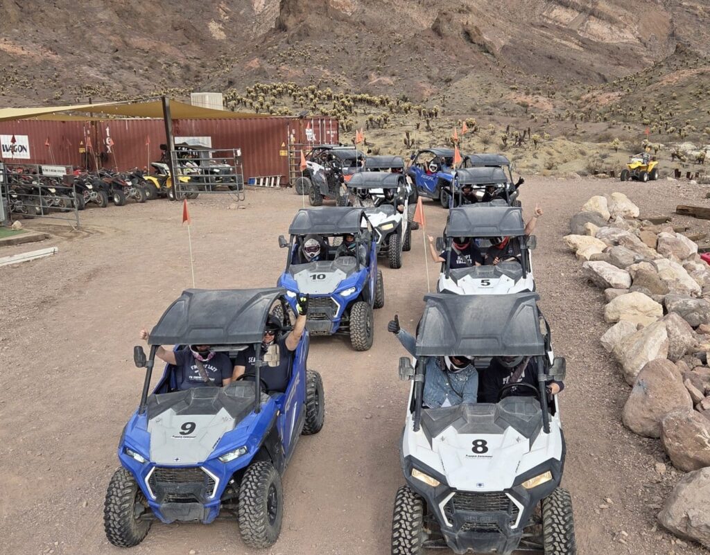 Adventurers in ATVs line up for a Nevada desert RZR off-road tour near Las Vegas, mountains, and historic Ghost Town sights.