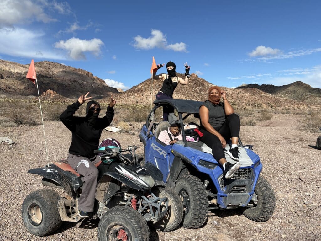 Adventurers on ATVs and quad bikes pose in Nevada desert near Las Vegas, with orange flags—perfect for ATV tours or RZR rides.