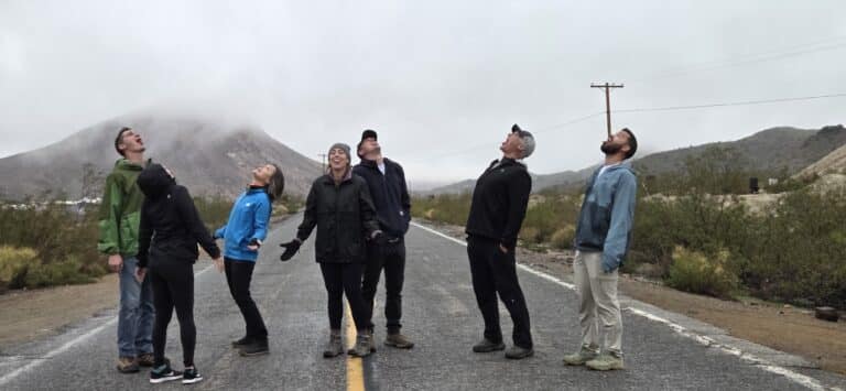 Group of friends on a foggy Nevada road near Las Vegas, smiling in outdoor gear, perfect for ATV tours or Colorado River sightseeing.