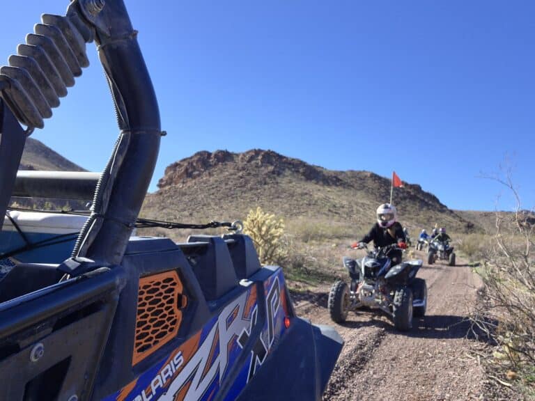 ATV tours near Las Vegas: riders explore desert trails, rocky Nevada hills, and sparse scenery under a clear blue sky.