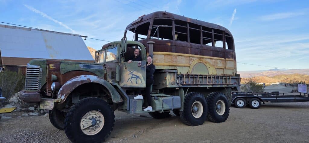 Two people on a vintage 6-wheel military-style truck near Las Vegas desert, perfect for Nevada ghost town sightseeing tours.