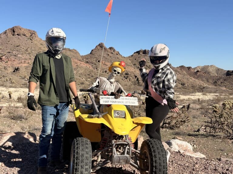 ATV tour near Las Vegas: two riders and a geared-up skeleton by a yellow ATV, ready for an off-road Nevada adventure.