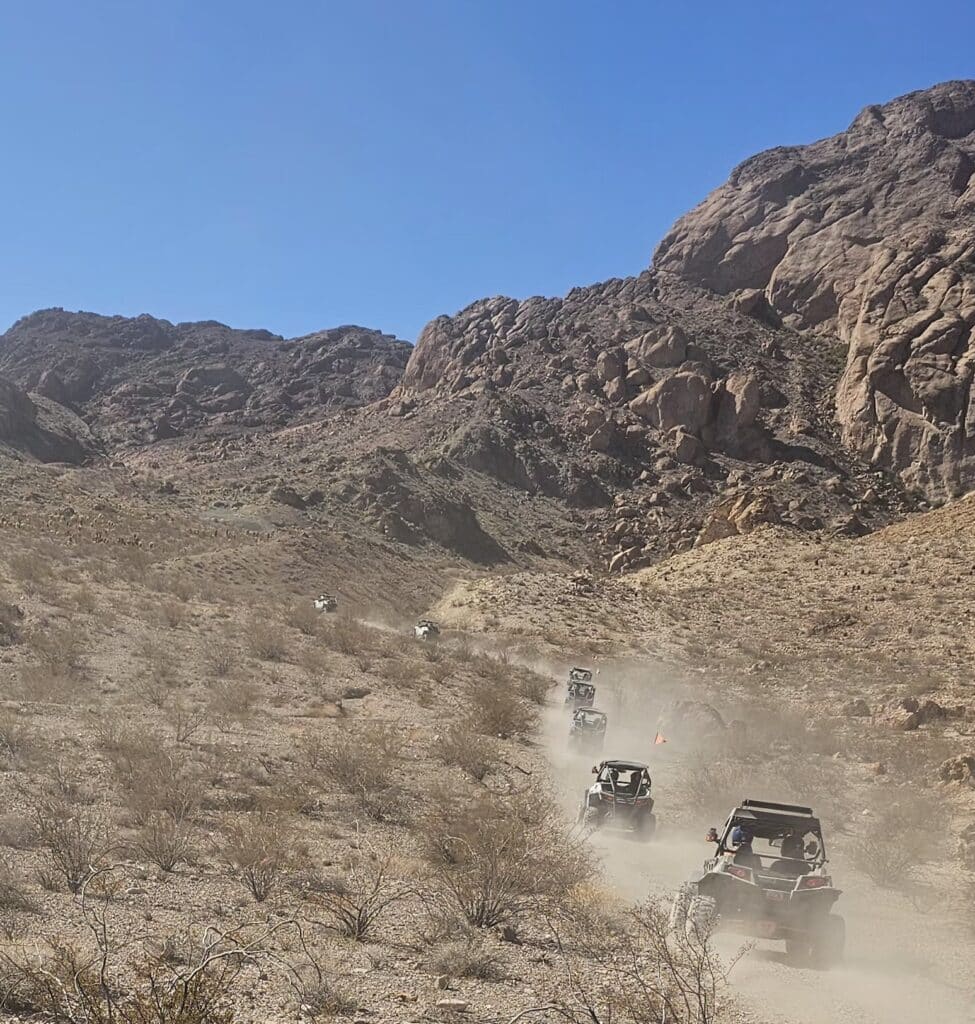 ATV tours near Las Vegas cruise dusty Nevada trails by rocky hills, perfect for Ghost Town sightseeing and RZR off-road rides.