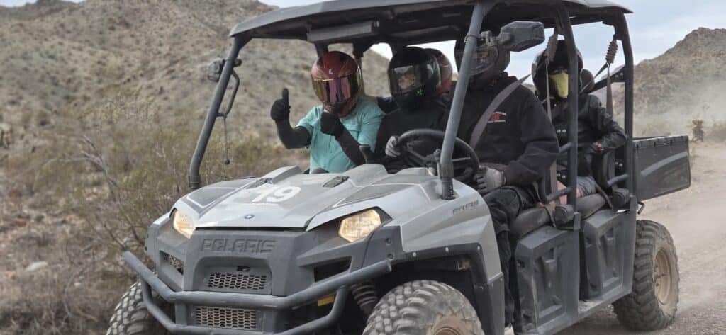 Four riders in helmets enjoy a Polaris RZR tour near Las Vegas, exploring Eldorado Canyon trails on a thrilling Nevada ATV adventure.