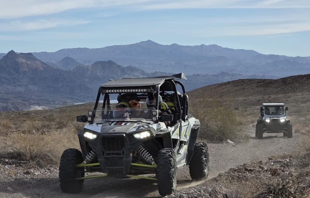 Experience thrilling RZR off-road rides near Las Vegas in Eldorado Canyon, Nevada, with mountain views and safety gear.