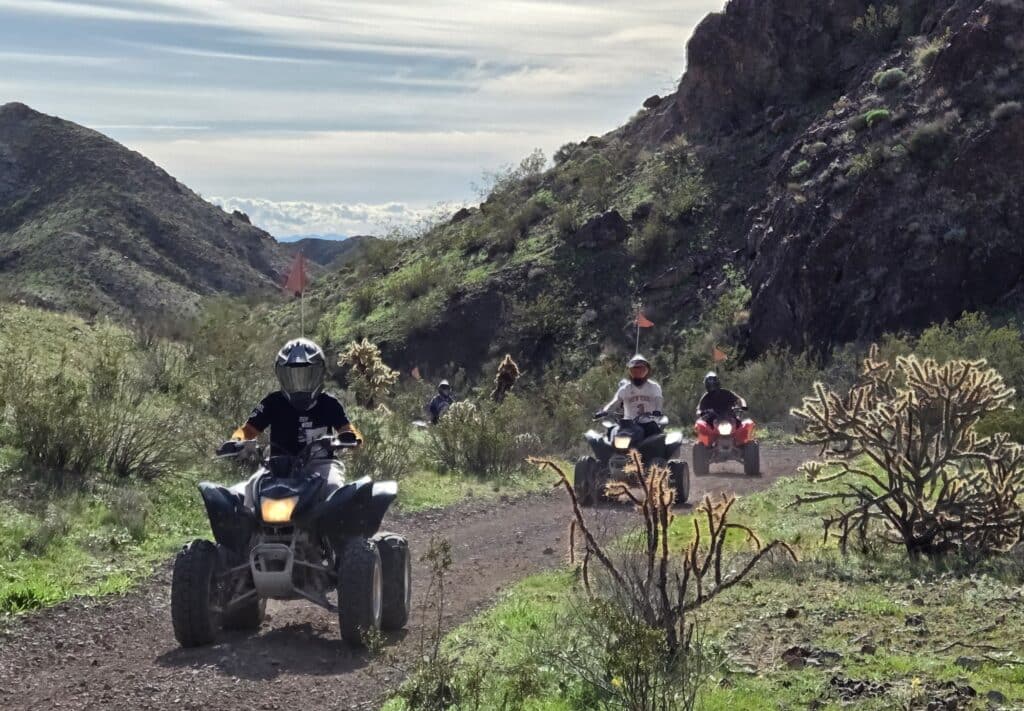 ATV riders explore Eldorado Canyon’s rocky trails near Las Vegas, Nevada, with mountain views on an off-road desert tour.
