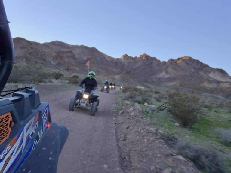 ATV riders explore a Nevada desert trail near Las Vegas with mountain views, perfect for RZR tours and Ghost Town sightseeing.