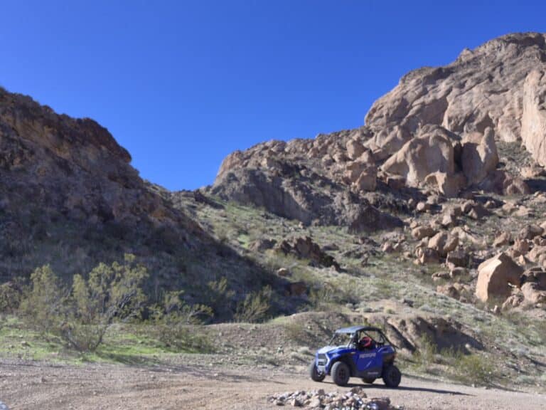 Explore Nevada’s rocky trails near Las Vegas on a blue RZR off-road ride under clear skies, perfect for ATV tours.