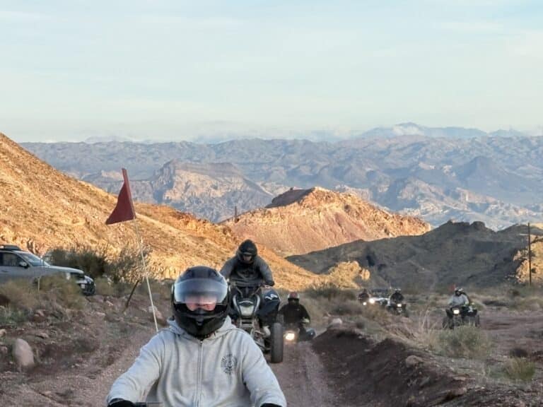 ATV and dirt bike tour near Las Vegas, Nevada, ride dusty desert trails with mountain views and a red flag leading the way.