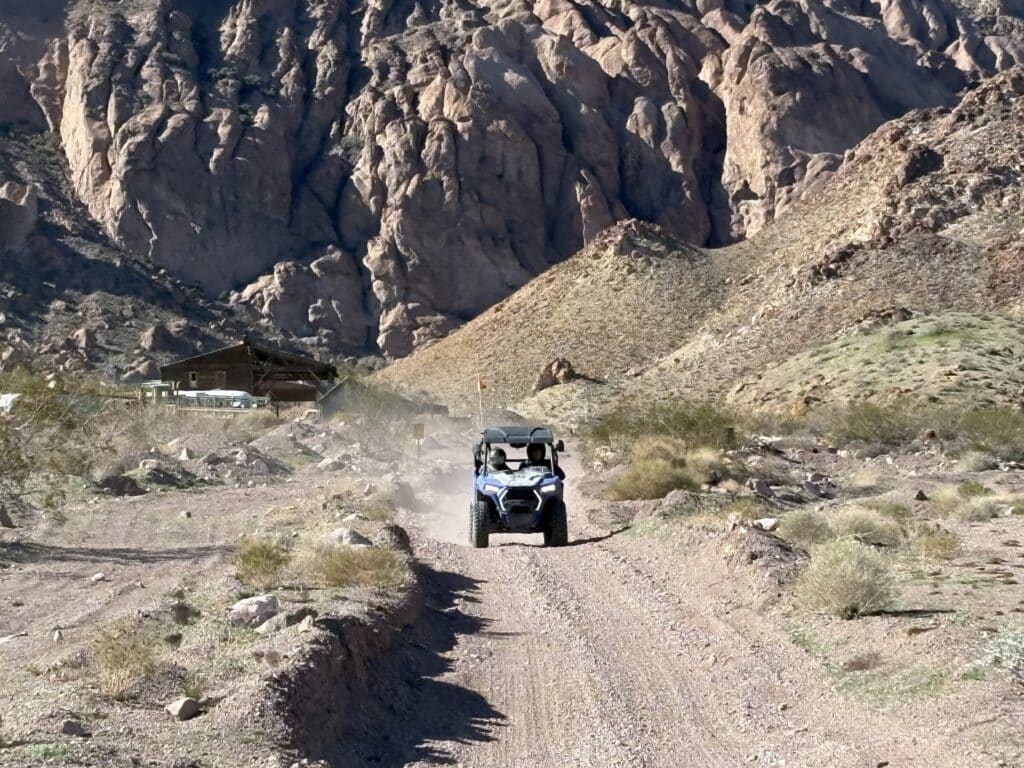 ATV tours near Las Vegas: an off-road vehicle kicks up dust on a desert trail with Nevada mountains in the background.