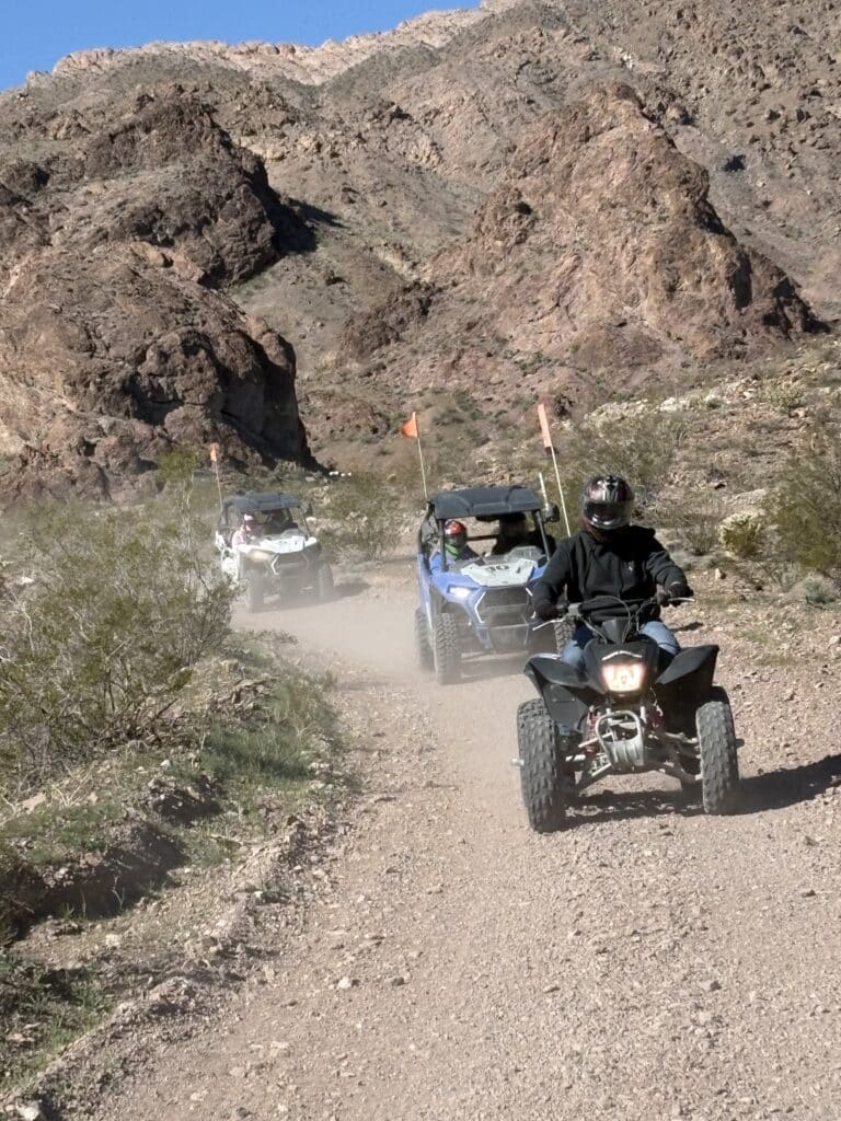 ATV and RZR off-road tours near Las Vegas, Nevada, on dusty desert trails with mountain views and orange flags flying.