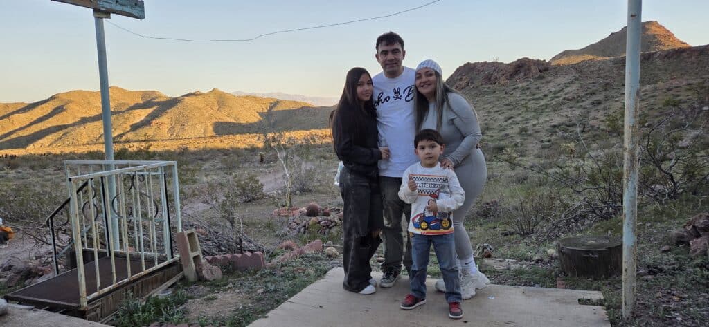Family of four on a wooden platform near Las Vegas, Nevada, with mountain views after a Colorado River ATV tour at sunset.