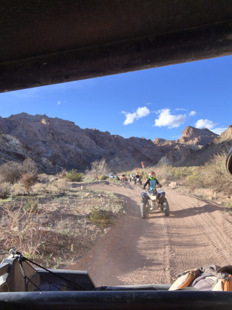 ATV riders explore a dusty Nevada desert trail near Las Vegas with mountain views, perfect for off-road tours and adventure seekers.