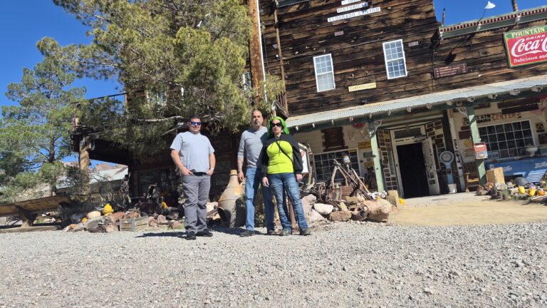 Visitors stand on a gravel path at a rustic Nevada ghost town near Las Vegas, ideal for ATV tours and Colorado River sightseeing.