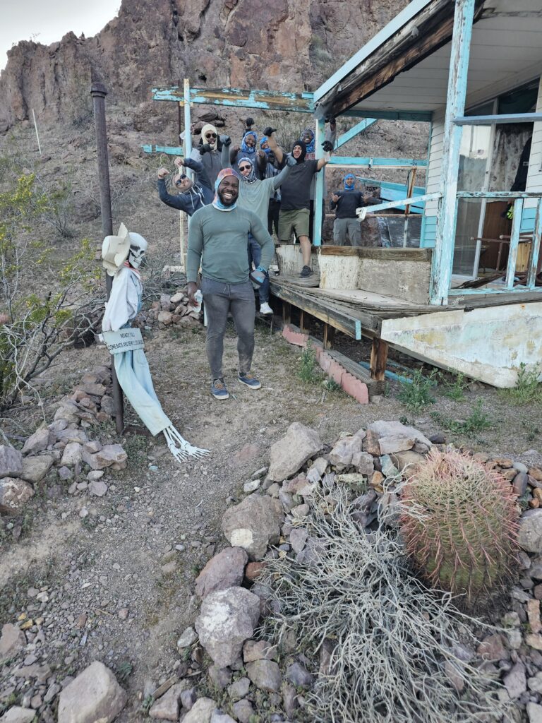Group poses cheerfully at a turquoise ghost town near Las Vegas, Nevada, perfect for ATV tours and sightseeing adventures.