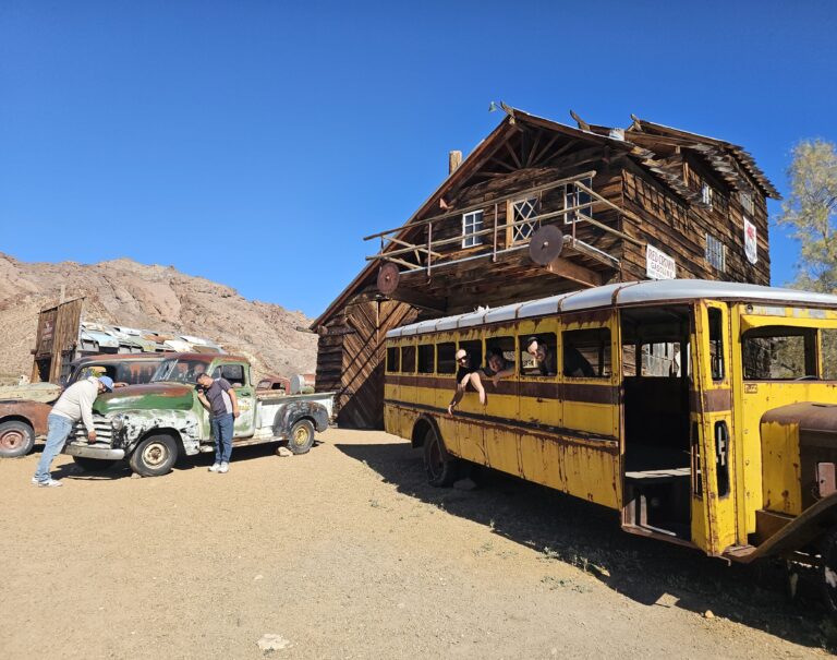 Discover a Nevada ghost town near Las Vegas: rustic wooden buildings, vintage vehicles, and desert hills—perfect for sightseeing tours.