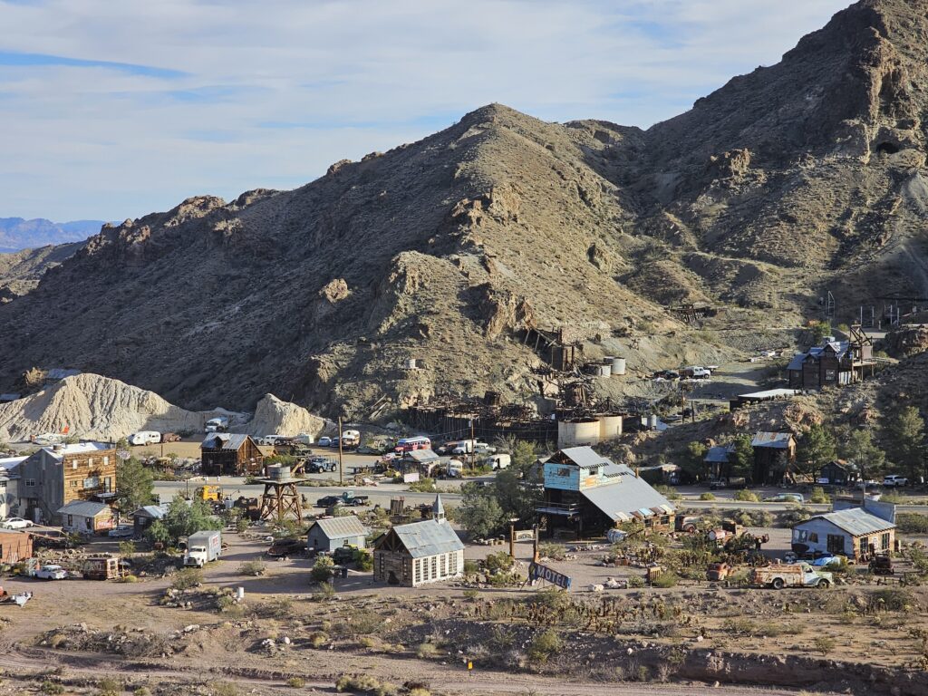 Historic Nevada ghost town near Las Vegas with wooden buildings, old vehicles, desert hills—perfect for ATV tours and sightseeing.