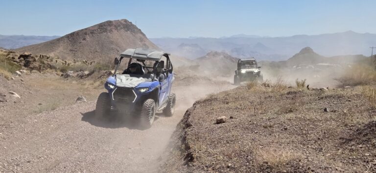 ATV vehicles on a dusty trail near Las Vegas, Nevada, with desert mountains—perfect for RZR off-road tours and Ghost Town sightseeing.