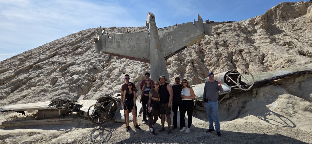 Eight people at a Nevada aircraft wreck site, perfect for Las Vegas ATV tours or Colorado River ghost town sightseeing adventures.
