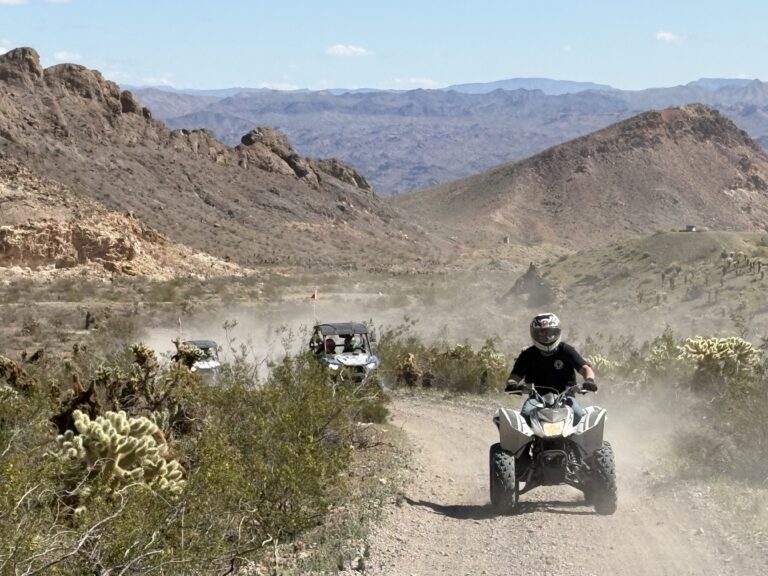 ATV riders explore a dusty Nevada desert trail near Las Vegas, surrounded by rocky hills—perfect for off-road tours.