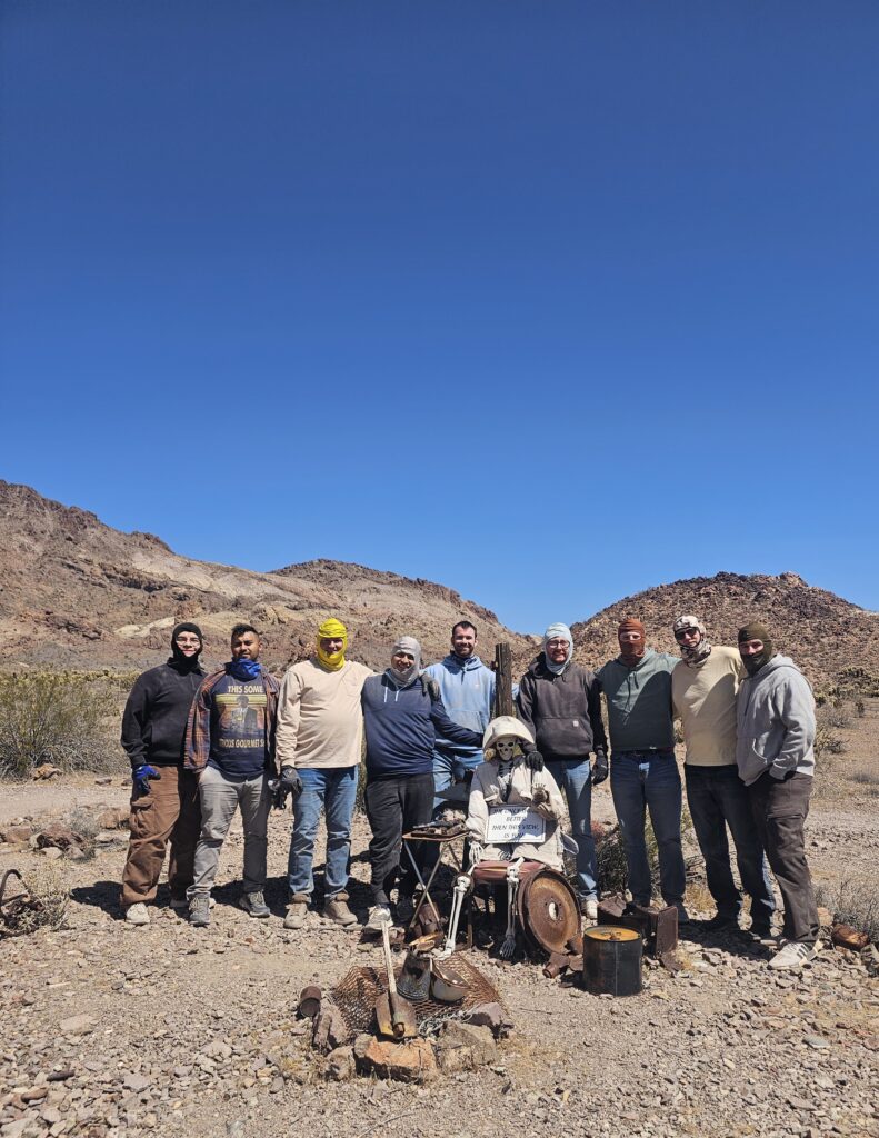 Group of ten in Nevada desert near Las Vegas, with mountains, campfire, and drums—perfect for ATV tours or Ghost Town sightseeing.