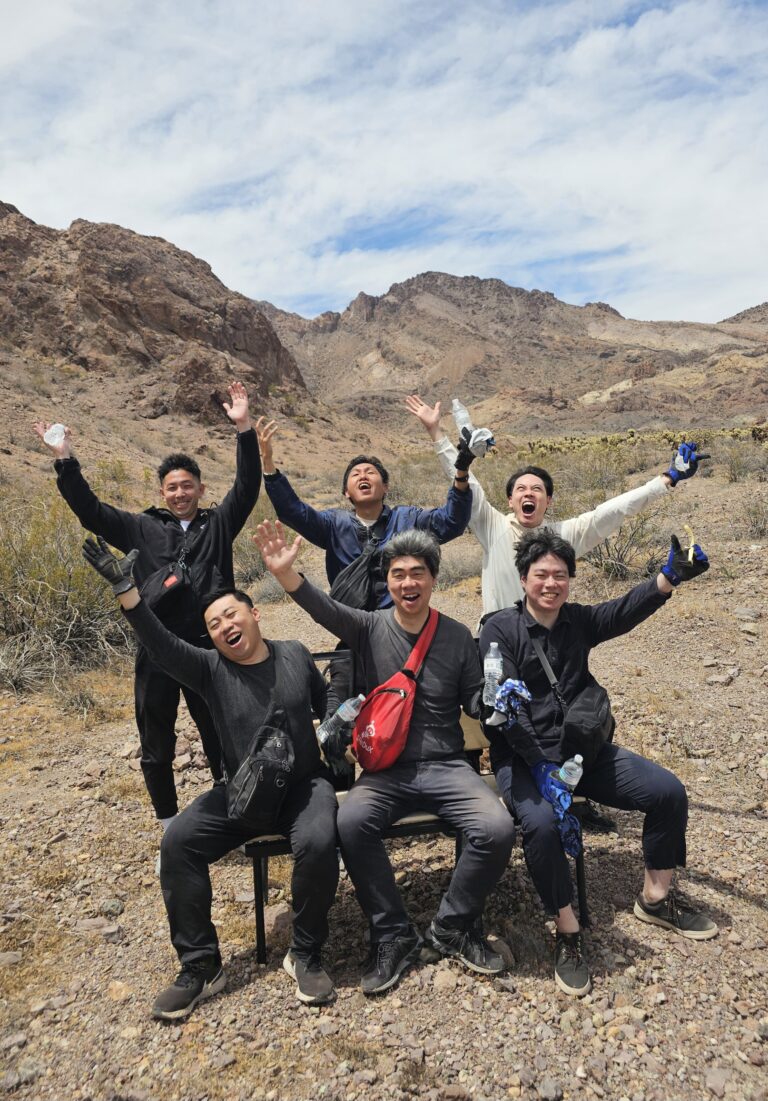 Group enjoying a break on a bench in the Nevada desert near Las Vegas, mountains behind them, ready for ATV and RZR adventure tours.