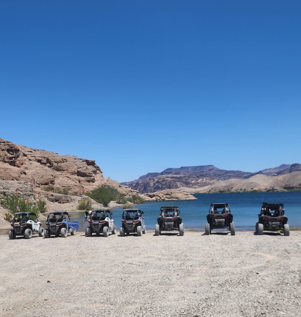 ATV and RZR off-road vehicles lined up near the Colorado River, Nevada desert hills, perfect for Las Vegas ghost town tours.