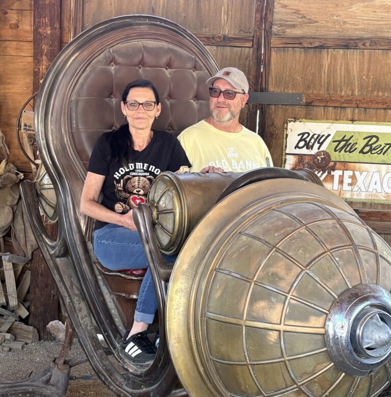 Two people on a steampunk time machine prop in a Nevada ghost town, perfect for Las Vegas ATV tours or sightseeing photos.