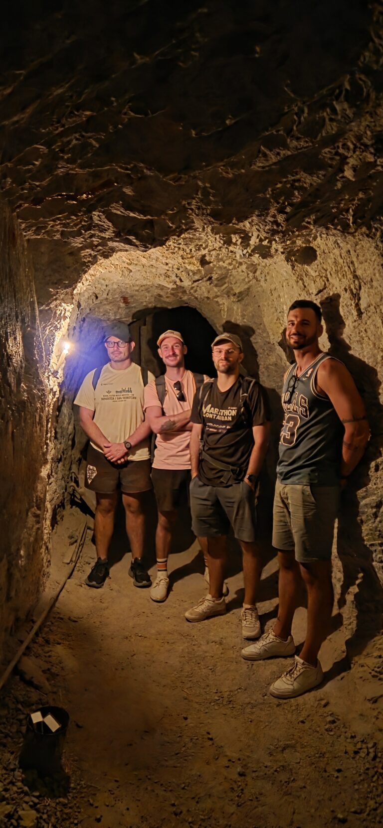 Four men with backpacks stand in a dim Nevada tunnel near the Colorado River, ready for Las Vegas ATV tours or RZR adventures.