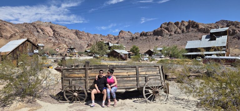 Visitors relax on a vintage wagon in a Nevada ghost town near Las Vegas, perfect for Ghost Town sightseeing and ATV tours.
