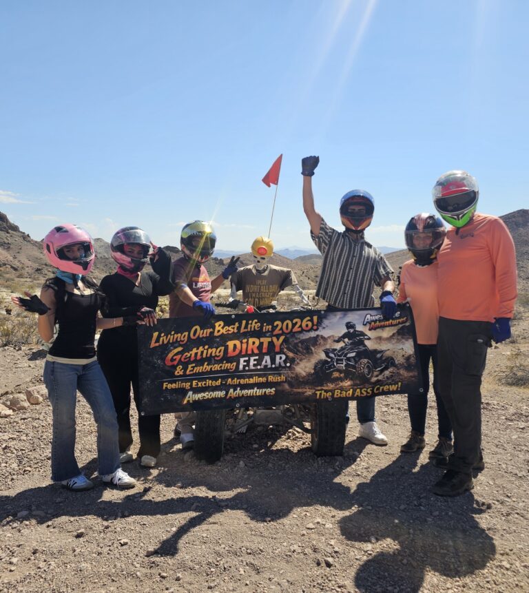 Six adventurers in helmets pose by ATVs on a rocky Nevada trail, banner reads “Live Boldly 2026”—ideal for Las Vegas ATV tours.