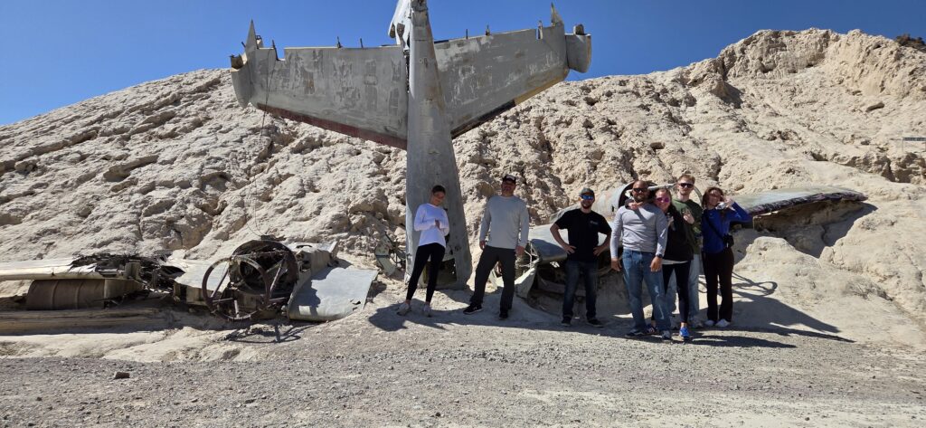 Seven people by a plane wreck in Nevada's desert near Las Vegas, perfect for ATV tours and Ghost Town sightseeing.