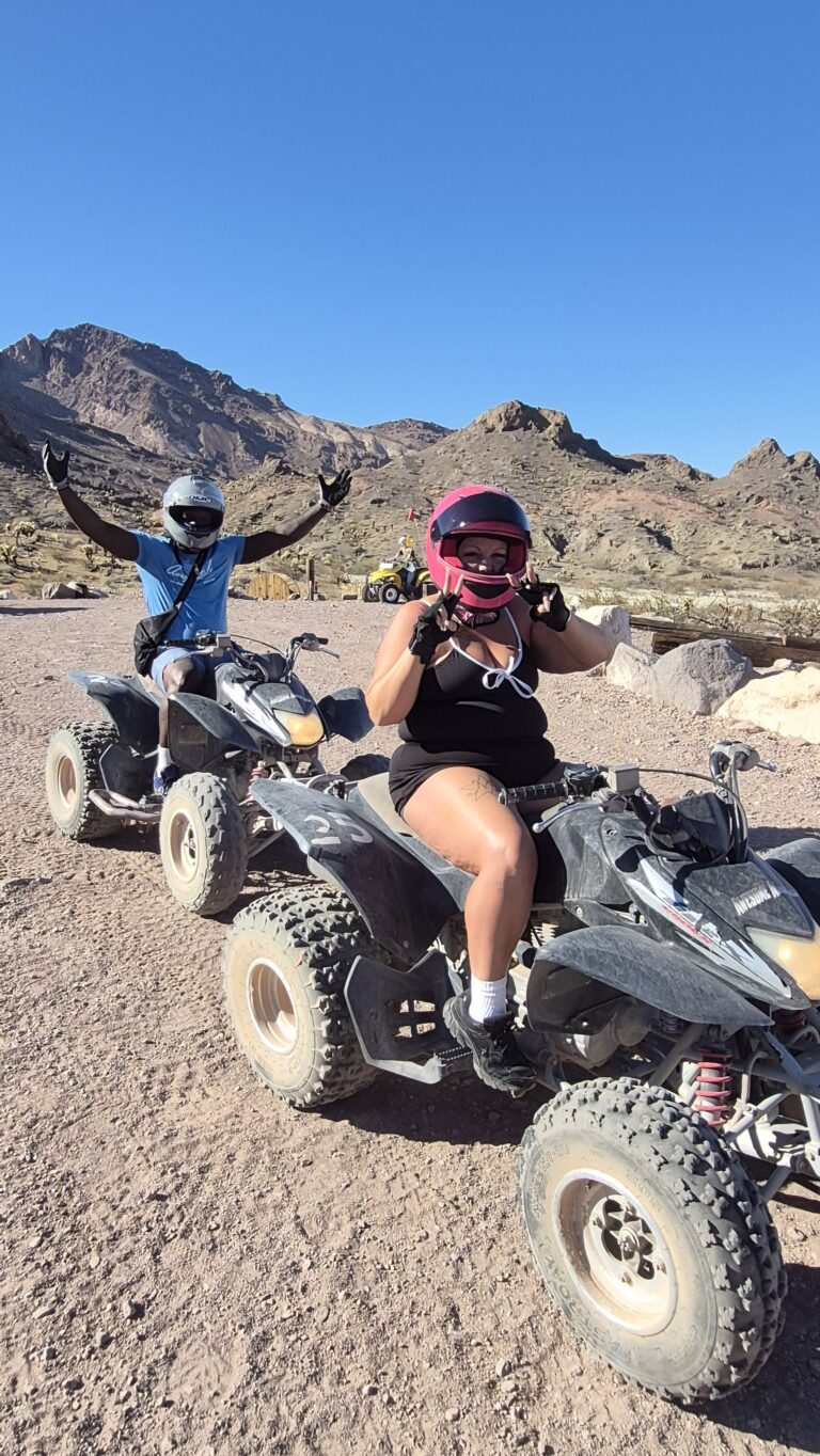 Adventurers on ATV tour near Las Vegas ride quad bikes on desert trails, with Nevada mountains and Colorado River views behind.