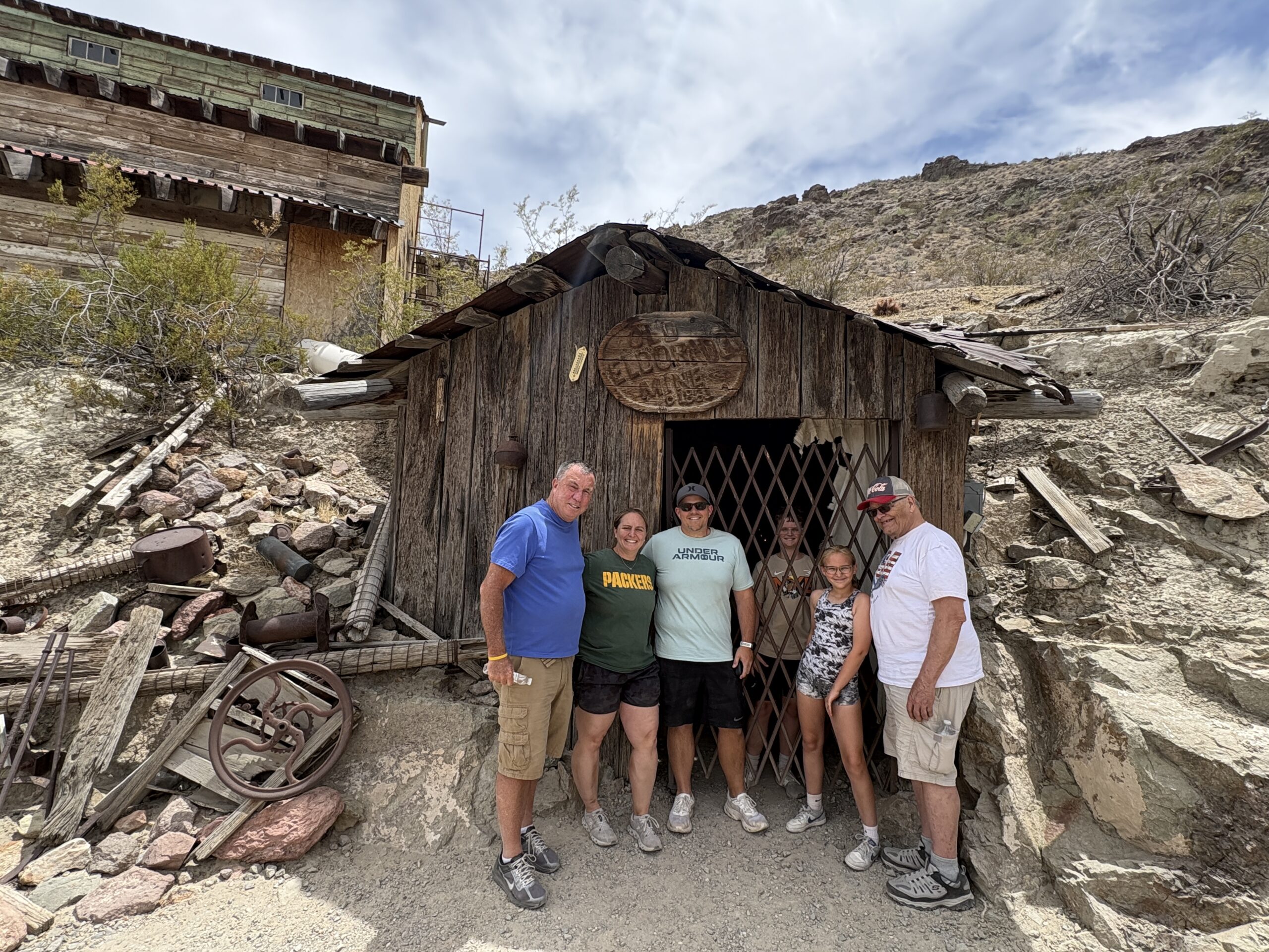 Group at Eldorado Canyon Mine Tours near Las Vegas, Nevada, by vintage mining gear, perfect for ghost town sightseeing and ATV rides.