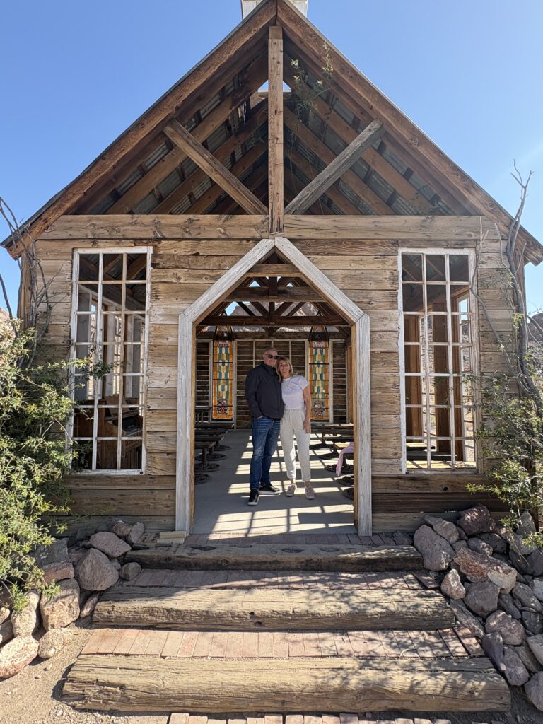 Couple at rustic wooden chapel in Nelson Ghost Town, Nevada near Las Vegas—perfect for ghost town sightseeing and adventure tours.