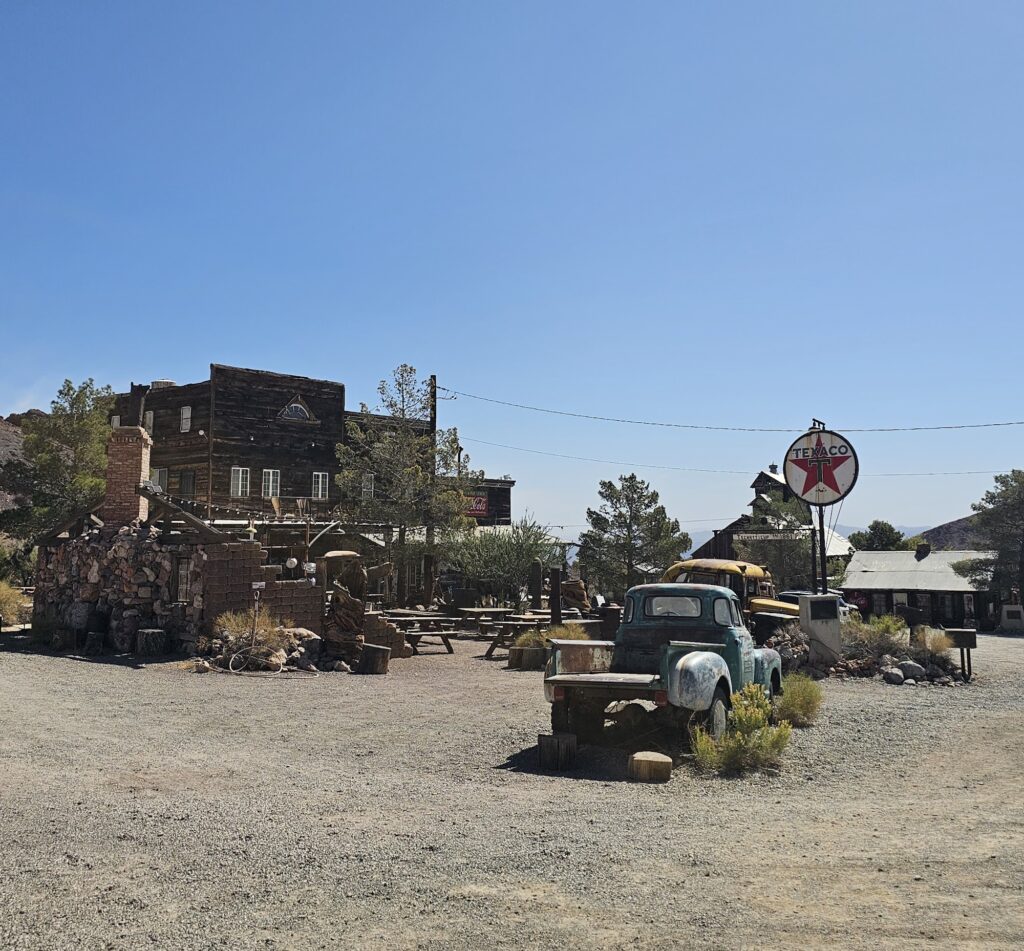 Vintage Texaco sign and green pickup in a rustic Nevada ghost town near Las Vegas, perfect for sightseeing or ATV tours.