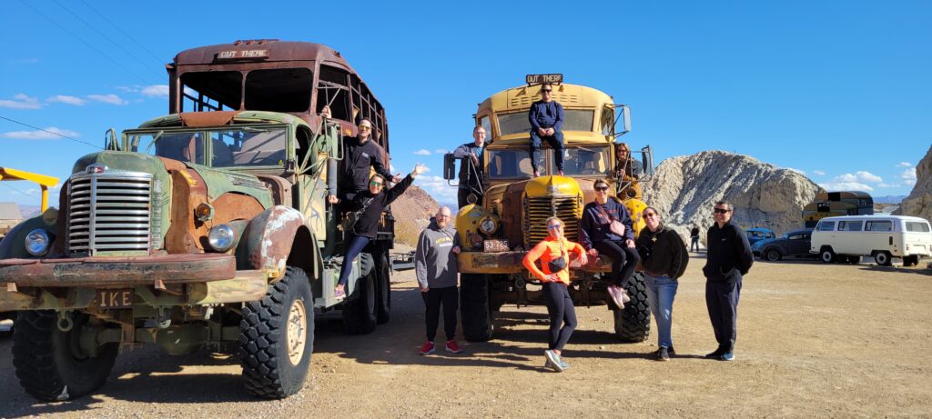 Visitors pose by vintage buses at Nelson Ghost Town near Las Vegas, Nevada, a top spot for ghost town sightseeing and photo tours.