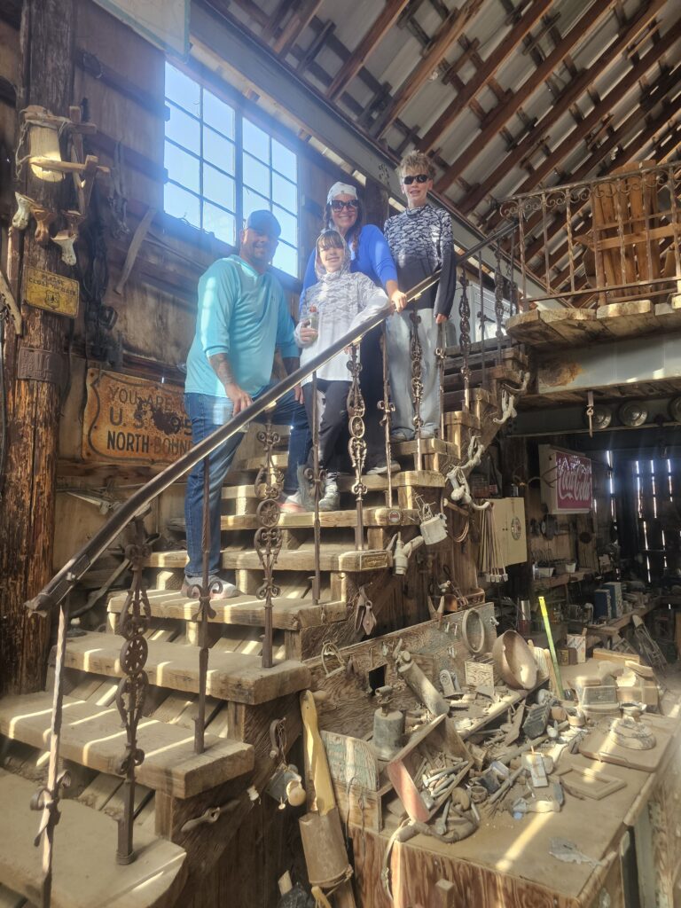 Smiling group on a sunlit wooden staircase in a vintage Las Vegas ghost town, perfect for Nevada sightseeing or ATV adventures.