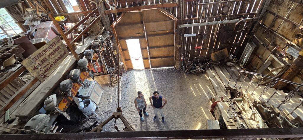 Aerial view of two people in a rustic Nevada barn with old farming gear, near Colorado River—perfect for ghost town sightseeing tours.