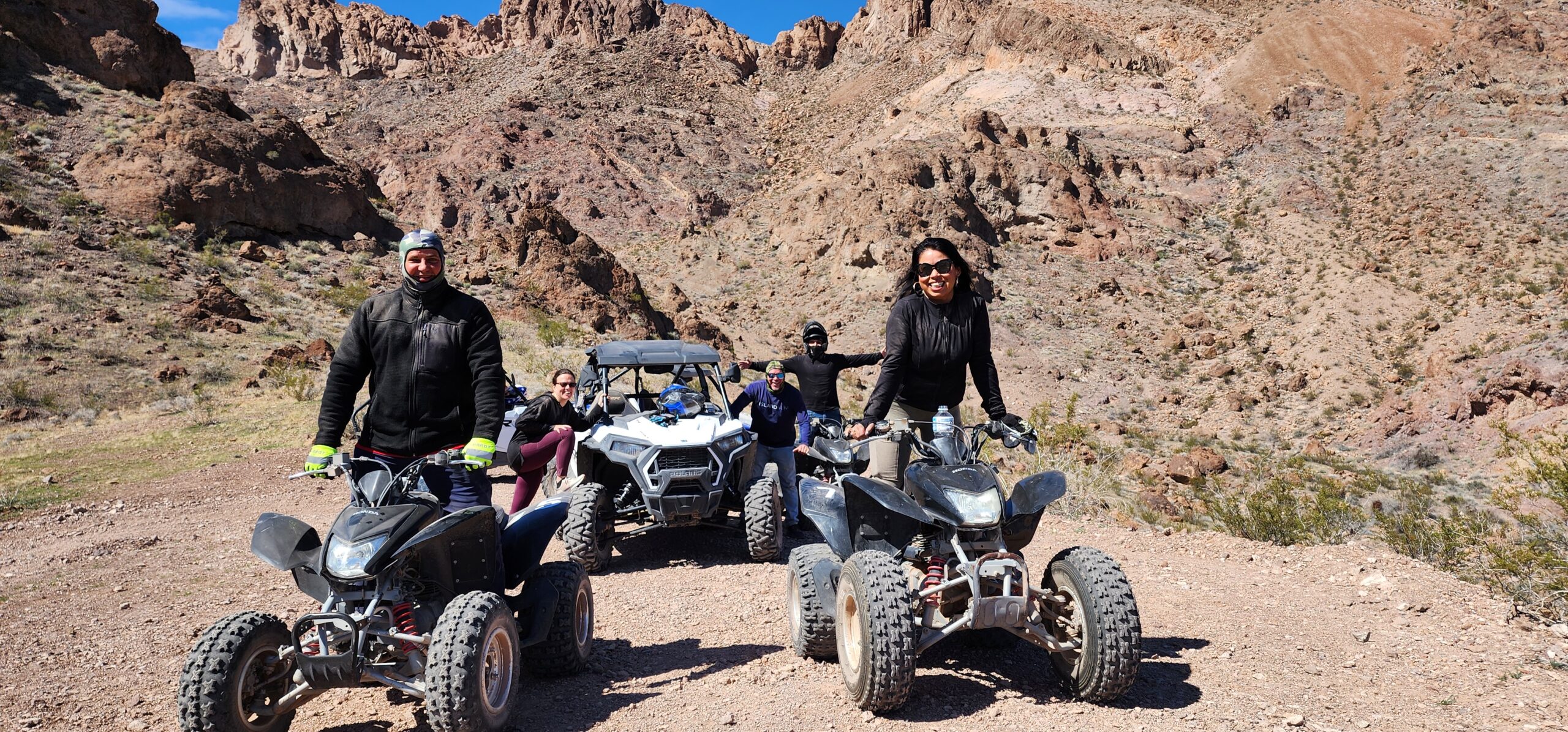 ATV and UTV riders enjoy a rugged Nevada desert trail near Nelson Ghost Town, outside Las Vegas with Colorado River views.