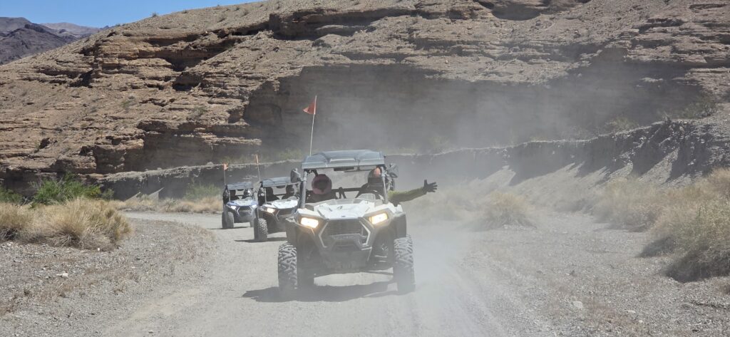 ATV riders explore a dusty Nevada desert trail by the Colorado River near Las Vegas, enjoying thrilling off-road adventures.